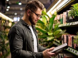 chico en una librería sosteniendo un libro