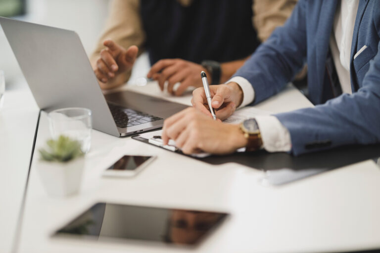 Free close up of two people hands, signing documents with laptop